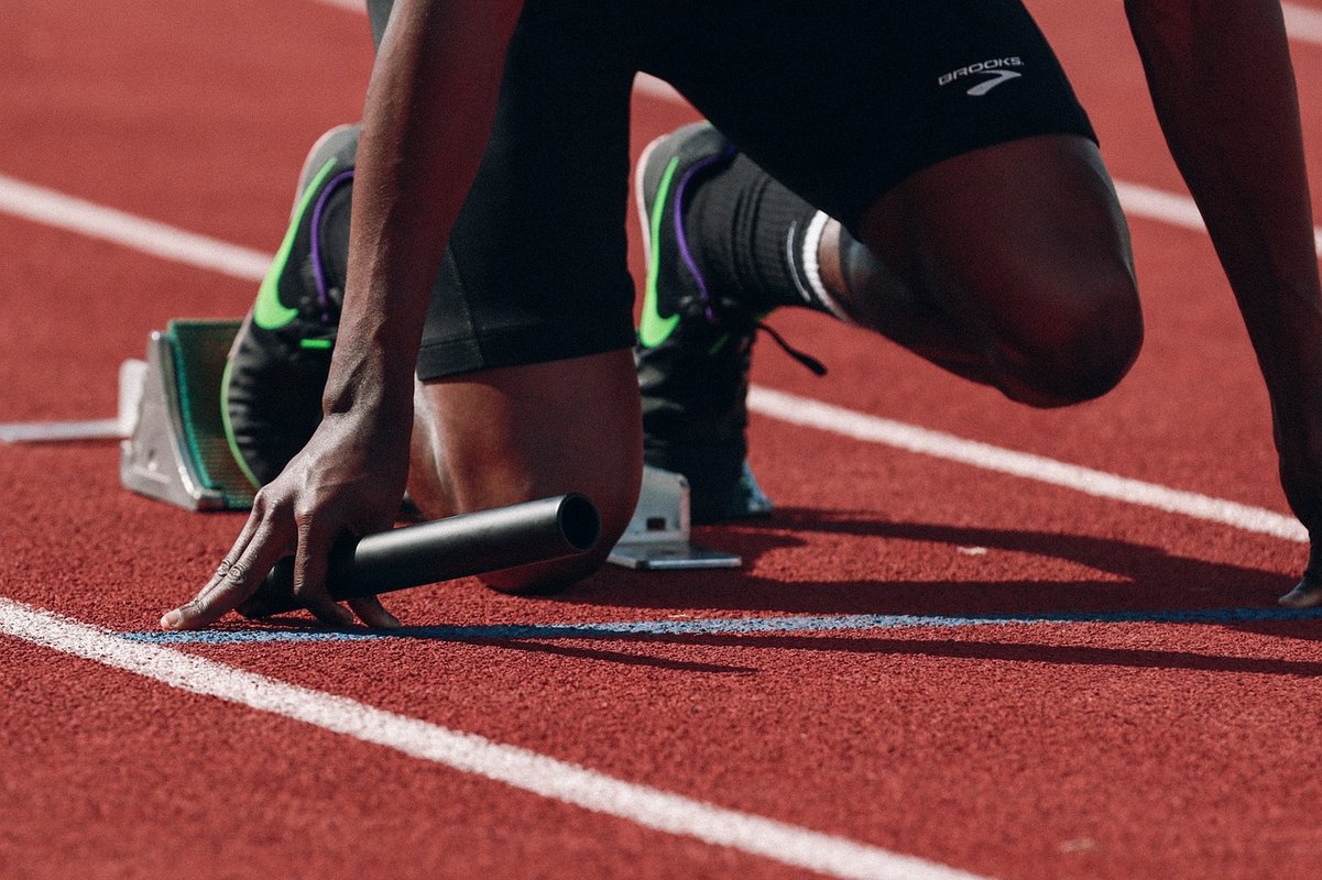 Photo d'une piste d'athlétisme ou l'on voit un athlète prêt a débuter une course